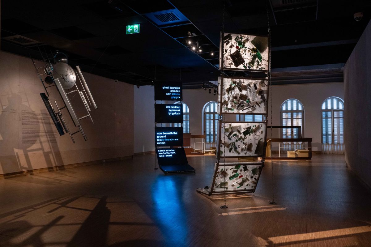 Dsc 4250 Önde: Yelta Köm, <i>hep seninleydim</i> (2026); arkada: Metincan Güzel, <i>Too Close to Home</i> [Eve Fazlasıyla Yakın] (2023–süregelen), <i>Barajdan Sızanlar</i> sergisinden görünüm, Salt Beyoğlu, 2026<br />
Fotoğraf: Metean Bars (Salt)